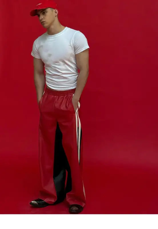 Someone wearing a white t-shirt, red track pants with white stripes, and a red baseball cap.