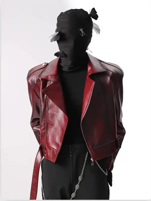 Cropped red leather motorcycle jacket with silver hardware and a belt.