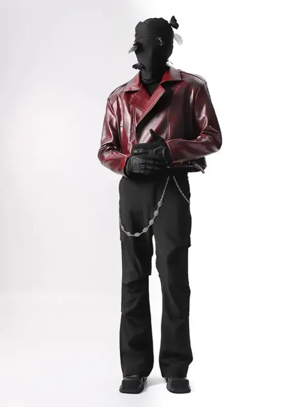 Silhouetted figure wearing a burgundy leather jacket, black pants, and a chain accessory.