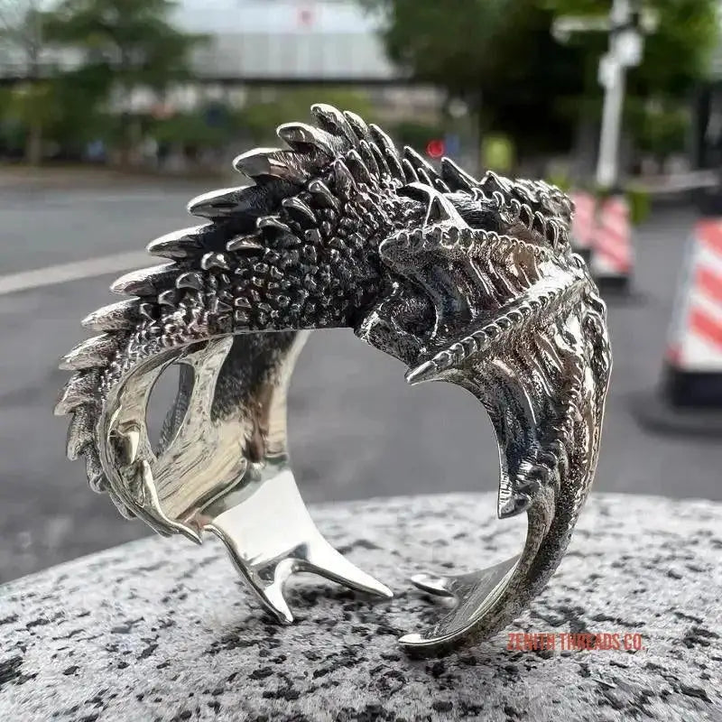 Silver dragon-shaped ring with detailed scales and spikes along its curved form.