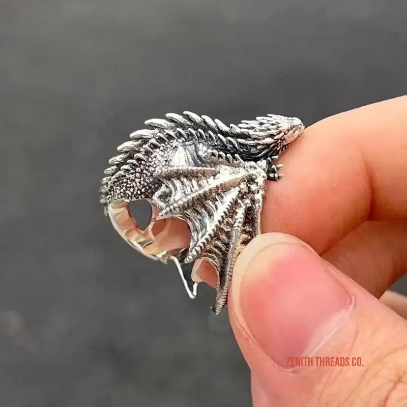 Detailed silver dragon ring with spread wings and intricate scale textures.