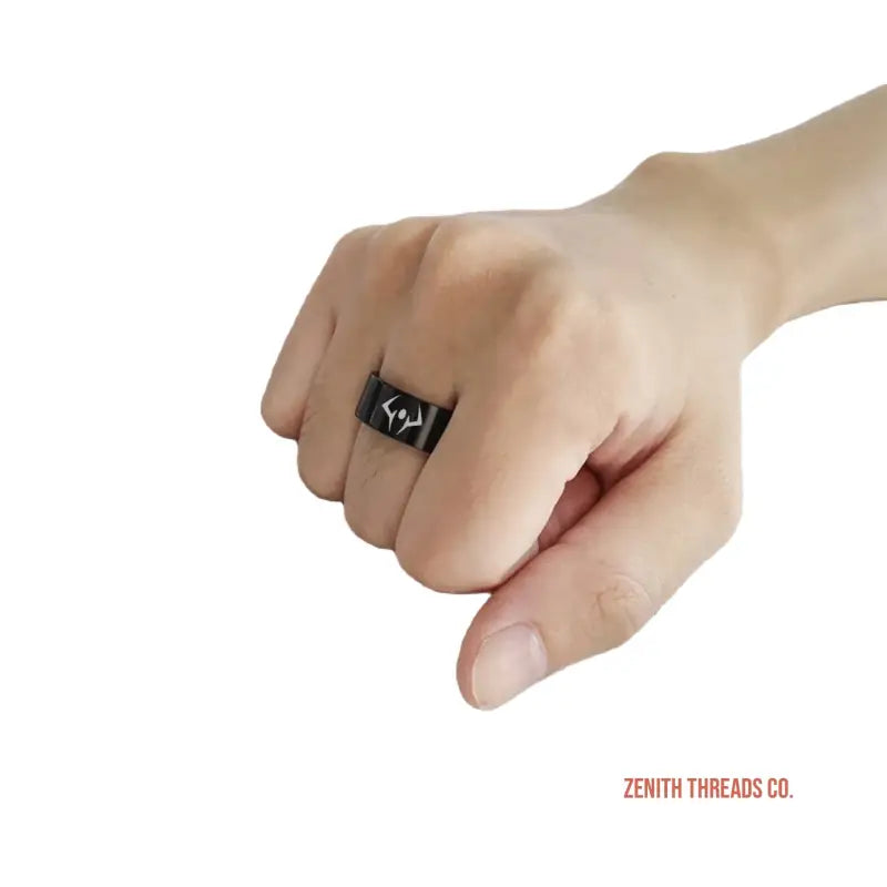 Black ring with a minimalist design worn on a hand.