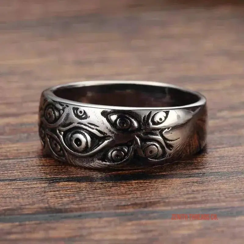 Dark metal ring with an engraved pattern of multiple eyes.