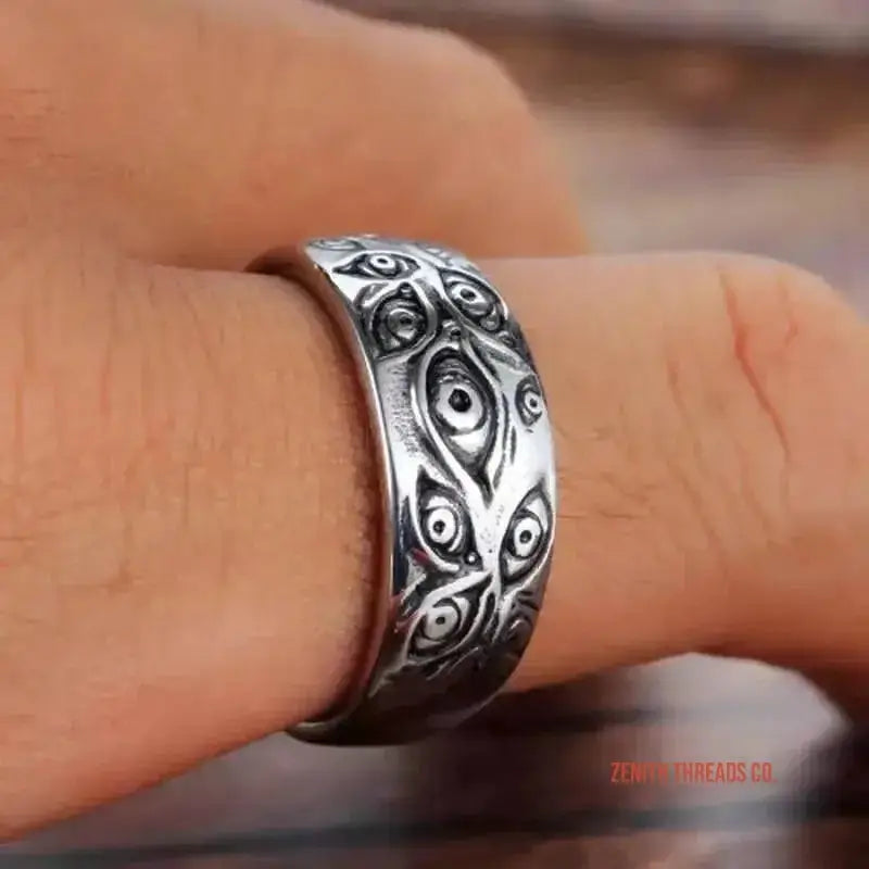 Silver ring with an ornate swirling pattern engraved into its surface.