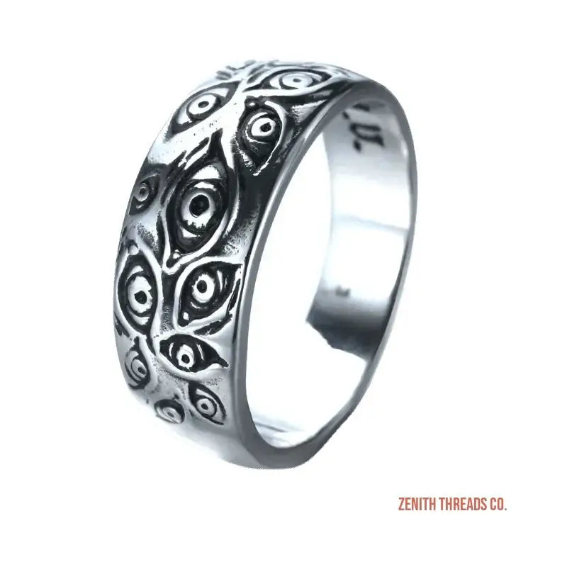 Silver ring with an engraved pattern of multiple eye shapes.