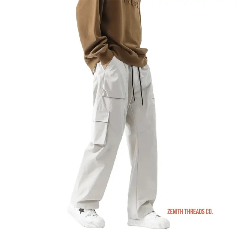 White cargo pants with side pockets and drawstring waist.