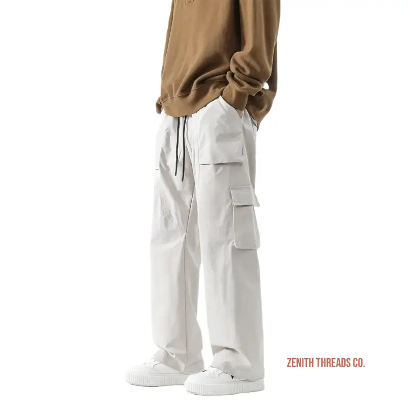 White cargo pants with multiple side pockets and drawstring waist.