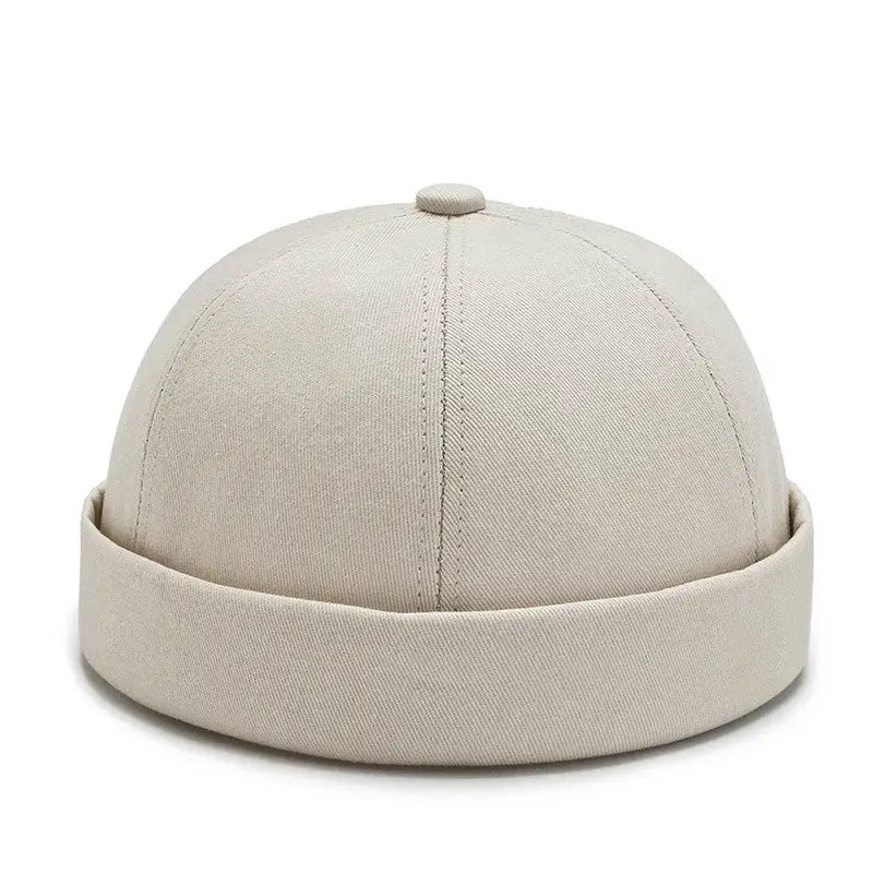 Beige cotton docker/fisherman cap with a rolled brim.