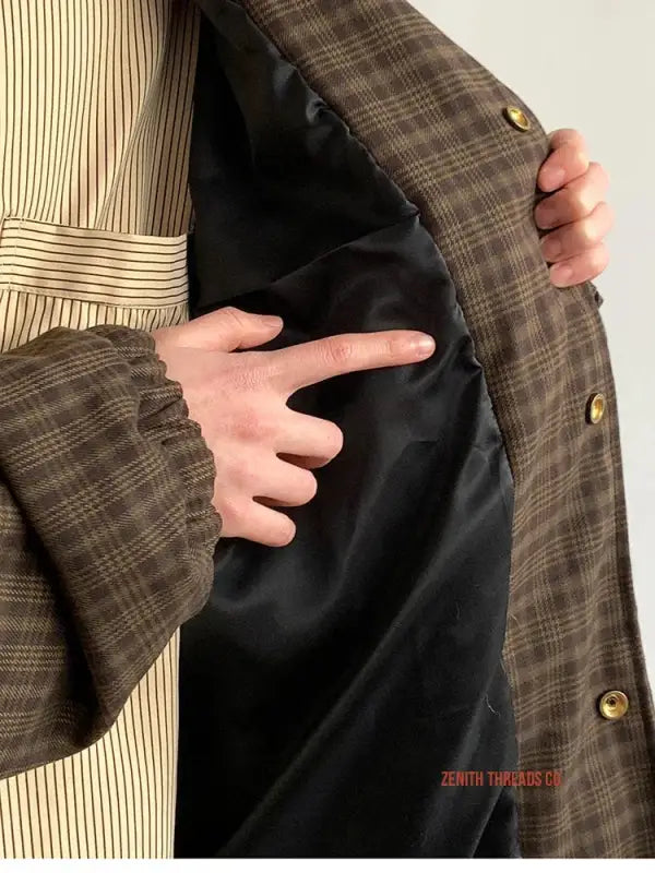 Brown plaid jacket with a black lining being held open to show the interior.