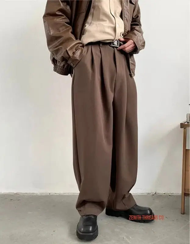 Wide-leg brown pleated trousers with a relaxed fit.