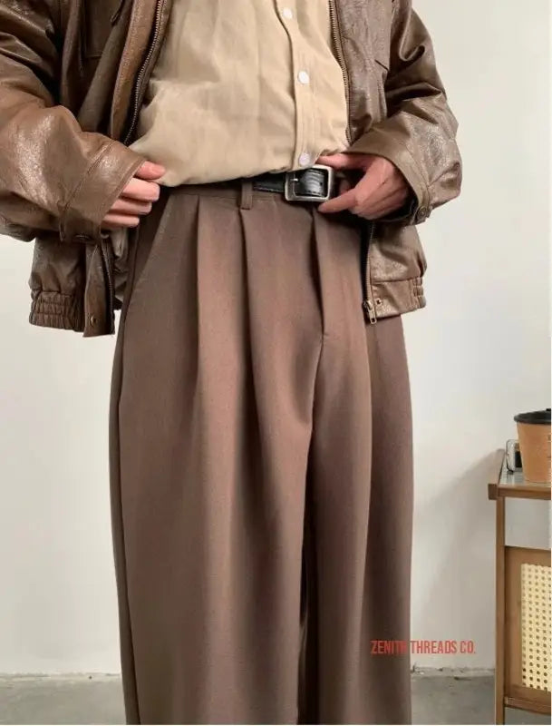 High-waisted pleated trousers in a warm brown color with a belt.