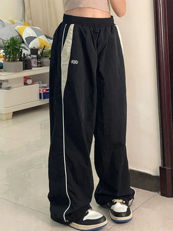 Black wide leg cargo pants with white stripes and drawstring waist for stylish comfort