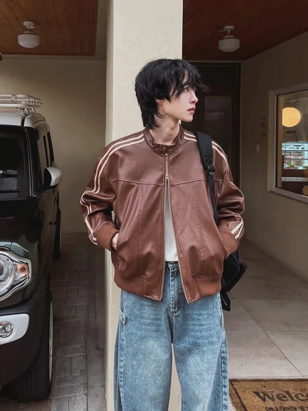 Brown track jacket with white stripes on the sleeves paired with light-wash denim jeans.